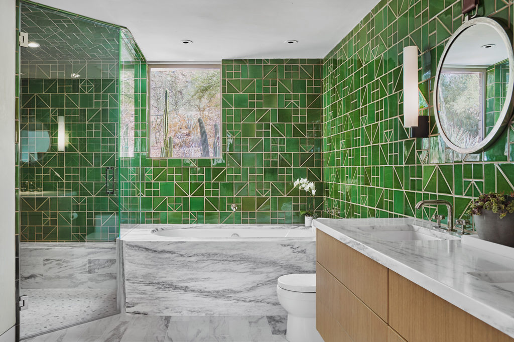 A bathroom with wall-to-wall green tile