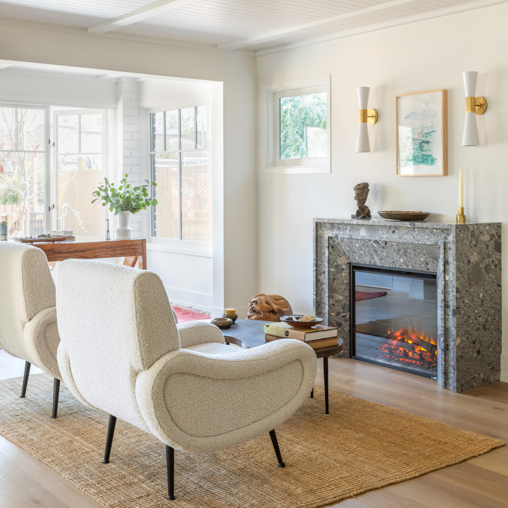 The living room in Historic Modern with a fireplace surround made entirely of stone by Walker Zenger
