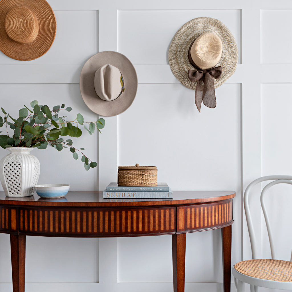 Collected hats from a local antique market hang in the front entry.