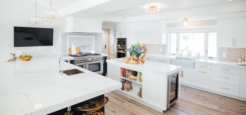 Kitchen by Mindy Laven with a large island and brass hardware and accents