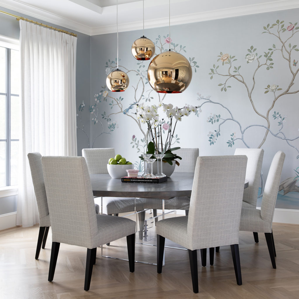 The dining room with a silver floral mural and Tom Dixon pendant lamps